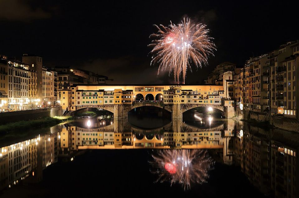 Fuochi d'artificio sopra il Ponte Vecchio di notte, riflessi nell'Arno